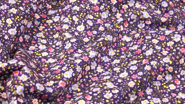 Draped cotton navy fabric with a small floral pattern, top view, background