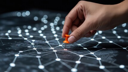 Strategic Pinpointing: A hand delicately places a vibrant pushpin onto a network, signifying a crucial connection, a pivotal point, or a strategic decision