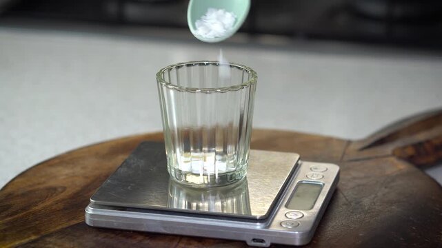 Measuring butter and wax on digital scale for homemade lip balm. DIY natural cosmetics process with organic skincare ingredients, eco-friendly beauty preparation, and handcrafted apothecary style.