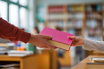 Obraz premium Student Handing Over Book in Classroom