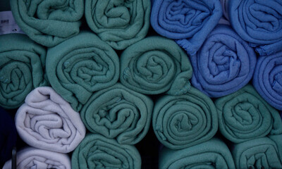 Fototapeta premium Rolled fleece plaids in various shades of blue and green