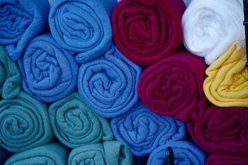 Rolled up microfiber blankets of various colors