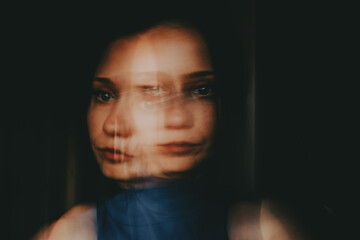 Abstract female portrait of a young woman with blurred double exposure effect. Artistic conceptual photo symbolizing mental health, identity crisis, stress, anxiety, depression and emotional confusion