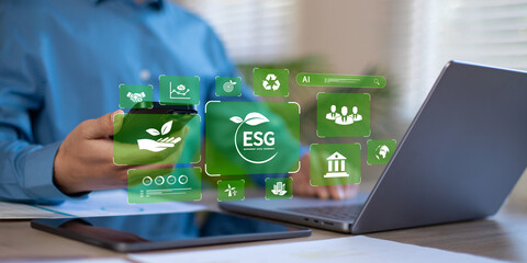 Businessman pressing a button on a laptop screen with ESG for environmental, social and governance...