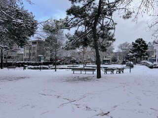 Quiet Urban Park Covered in Fresh Snow with Benches