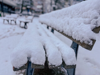 Natural Light Close-Up of a Wooden Bench Covered in Winter Snow