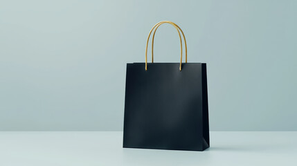 simple black shopping bag with gold handles, set against a light background, conveying a minimalist aesthetic perfect for retail branding.