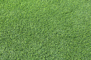 Fototapeta premium close-up of a lush, green artificial turf. The synthetic blades of grass are perfectly aligned and create a uniform