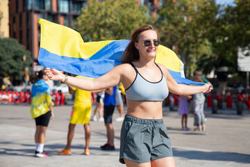 Obraz premium Patriotism and sport, A girl runs with a Ukrainian flag