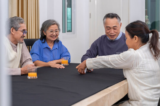 cheerful senior friends enjoy playing cards game together at home,concept elderly people activity, entertainment,recreation,encourages social interaction,help memory retention