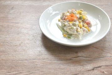 mashed tuna with corn and garden pea couple cabbage vegetable topping shrimp egg salad dressing cream sauce on plate