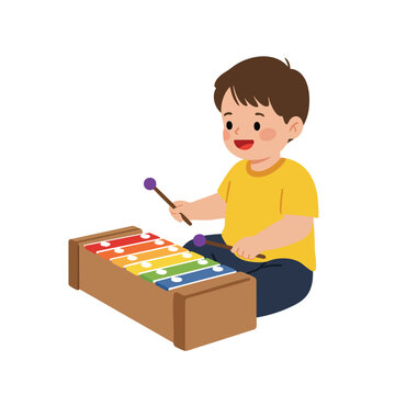 a toddler sitting on the floor, wearing a bright yellow t-shirt, happily striking the colorful keys of a xylophone with two small mallets