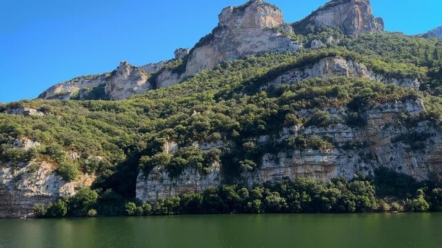 Scenic view of the Sobron Reservoir on the Ebro River, located between Alava and Burgos, Spain. Surrounded by green mountains and dramatic rock formations, this water landscape is a popular