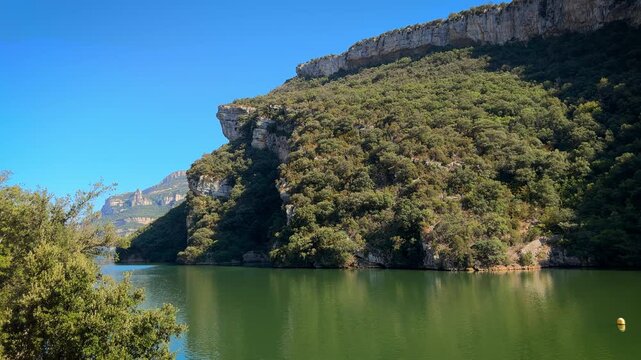 Scenic view of the Sobron Reservoir on the Ebro River, located between Alava and Burgos, Spain. Surrounded by green mountains and dramatic rock formations, this water landscape is a popular