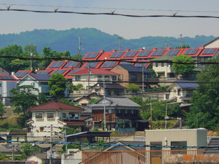 Solar panels are installed on the red roof of the houses in the residential area.