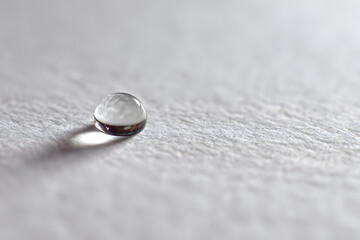 a single glass ball sitting on top of a white surface