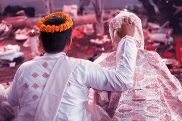 Bride and groom take part in traditional rituals during an Assamese wedding ceremony