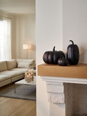 Black pumpkins decorating modern fireplace mantel for halloween