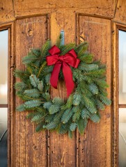 Christmas wreath hanging on rustic wooden door