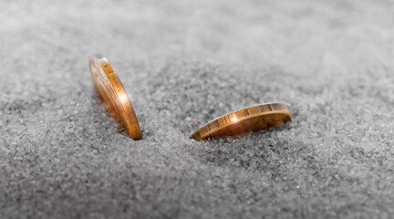 Two coins in the sand