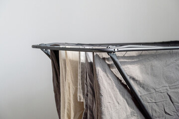 Clothes drying rack with various clothing hung. Domestic laundry and housework concept.