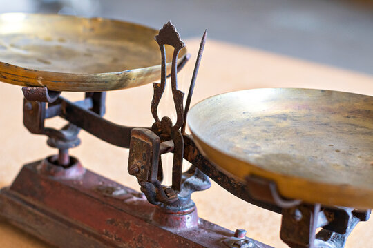 Old vintage scale with two empty brass trays, showing signs of wear and rust, symbolizing balance, justice, and the passage of time
