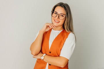 woman with long hair and glasses stands on white background