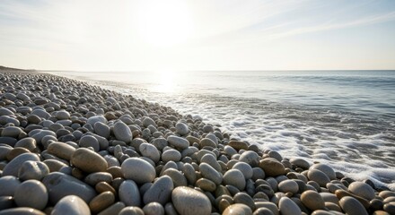 Pebbled beach ocean waves bright sun