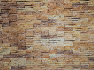 Faux Concrete Wall Panels. The walls of the building are decorated with stone panels. The exterior walls are decorated with unevenly colored brown brick panels. faux stone, artificial stone wall, 
