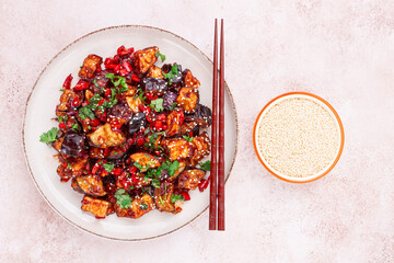 fried eggplant, Chinese style, in sweet and sour sauce, with pepper and sesame seeds. on a white plate,