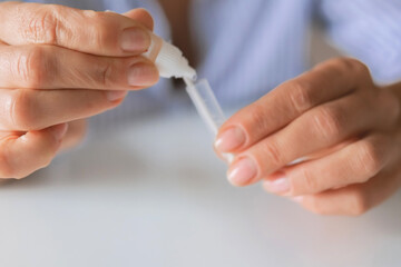 Hands using an at-home rapid antigen test for remote care: self-swab, easy sample, quick result. Ideal for telemedicine, COVID or strep screening, digital health, online doctor pharmacy