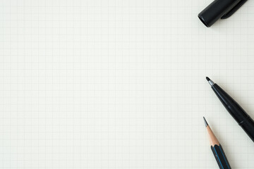 Top view, Close-up of Black Felt-tip Pen and Pencil on Graph Paper Background, Copy Space for Text, Flat Lay Concept.
