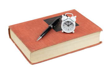 Red hardcover book with black pen and white alarm clock isolated on white background with clipping path.