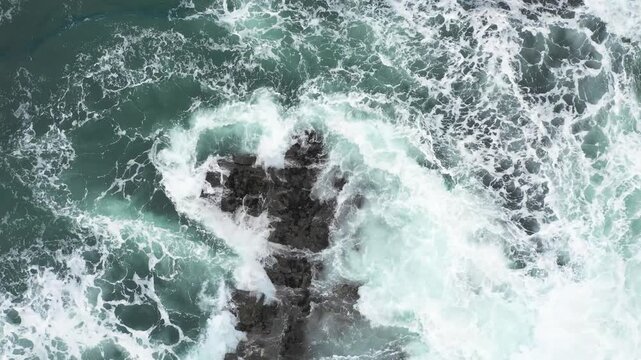 Aerial top view of rocks in the sea - Aerial video of majestic waves splashing on the rocks in Scotland - Travel and nature concepts
