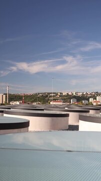 futuristic concept of underground city with circular skylights bringing daylight deep below surface modern architecture blends with natural hillside urban skyline and industrial chimne
