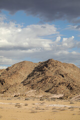 Fototapeta premium Rugged arid mountains of the Richtersveld desert area with summer storm clouds