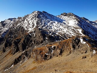 Mountain Peak View over the Swiss Alps with Snow-Covered Mountains and Shadows in Clear Autumn Light