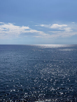 Glittering blue ocean and sunny sky vertical.