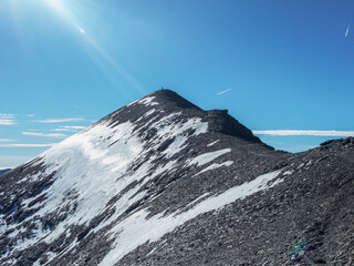 Lone Hiker Standing on Snowy Mountain Summit in the French Alps – Achievement and Adventure at High Altitude