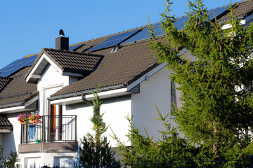 Home with solar panels and greenery on a clear day in a suburban area