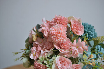 A photograph of beautiful flowers arranged in a vase, taken indoors