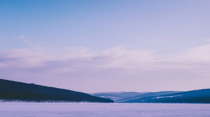 A serene landscape of distant mountains under a vast sky with calm waters below,