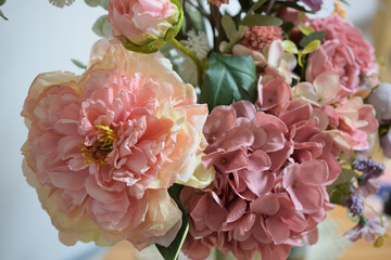 A photograph of beautiful flowers arranged in a vase, taken indoors