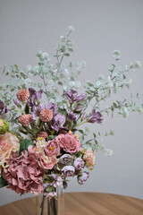 A photograph of beautiful flowers arranged in a vase, taken indoors