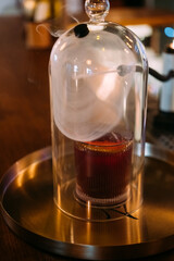 Drink presentation. Cocktail fume. Glass cap cloche cold smoke covering alcoholic beverage. Professional device for making aroma aperitif.