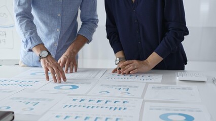 Professional team analyzing financial reports, sharing insights and planning strategic decisions in modern workplace setting. Business people concept