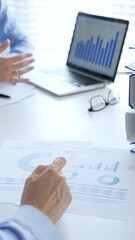 Business partners reviewing financial documents charts and diagrams , working collaboratively at white desk in office. Audit and taxes in business