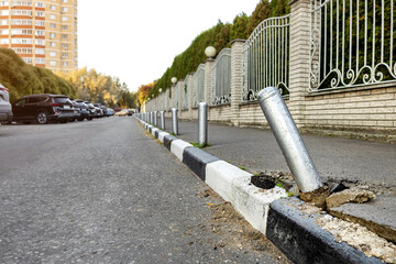 damaged parking post after being hit by a car. the car hit a parking bollard. parking bollards for pedestrian protection