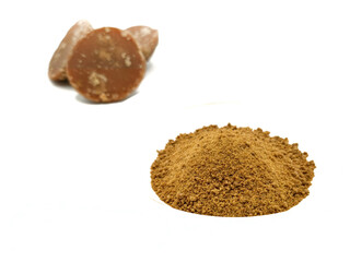 three pieces of natural brown palm sugar or coconut sugar in powder on white plate and in semicircular shapes form isolated on white background