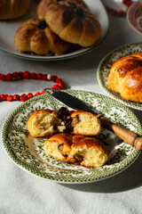 Pumpkin shaped yeast buns with marzipan filling served on vintage plates with natural Autumn decorations on the table.